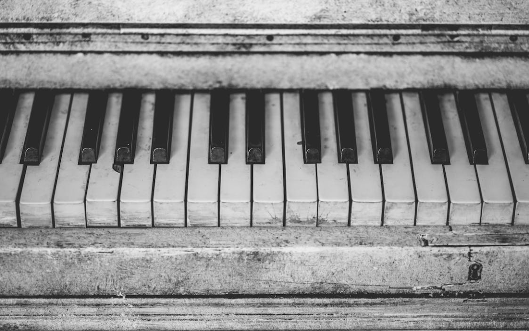 Greyscale photo of an old piano